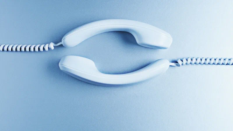 A white telephone handset rests on a blue surface, its coiled cord extending to the side. This symbolizes Treasury’s response to public comments on the Interim Rule, a process Civilytics views as working as intended.